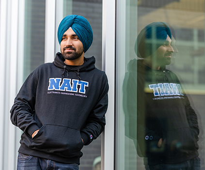 NAIT Student Wearing Program Campus Hoodie